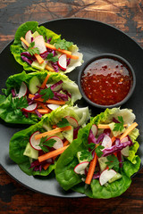 Vegetable lettuce wraps with carrot, onion, radish, red cabbage, cucumber and sweet chilli sauce