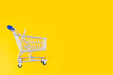 empty shopping cart over yellow background