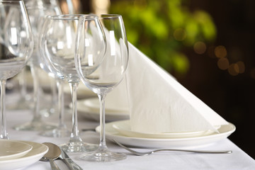 Table setting with empty glasses, plates and cutlery indoors