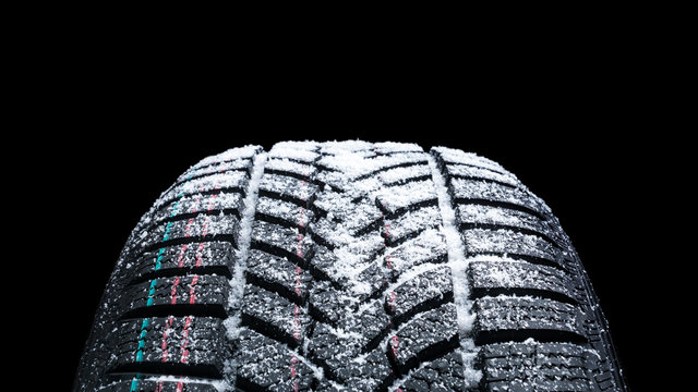 Winter Car tires with snow close-up wheel profile structure on black background