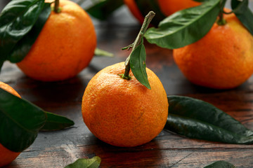 Mandarins Tangerines with green leaves on wooden table