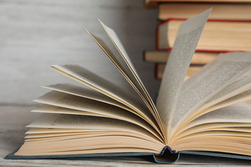 Open hardcover book on white wooden table, closeup
