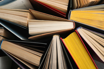 Stack of hardcover books as background, top view