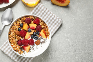 Healthy homemade granola with yogurt served on grey table, flat lay. Space for text