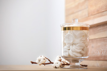 Jar with cotton pads on table indoors