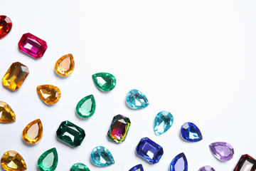 Different beautiful gemstones on white background, top view
