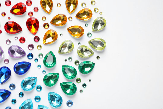 Different beautiful gemstones on white background, top view