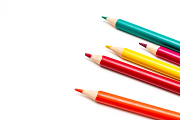 A set, assortment of colorful wooden pencils of different colors laying in mess on white background with copy space