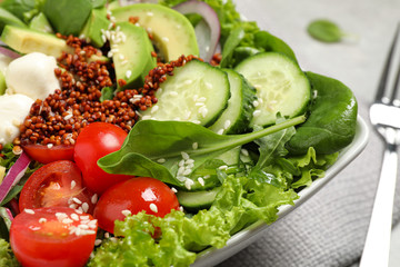 Delicious avocado salad with quinoa on light grey table, closeup