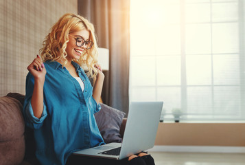 attractive young girl working at computer, happy to win.