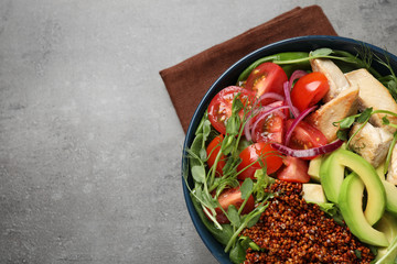 Delicious avocado salad with quinoa on grey table, top view. Space for text