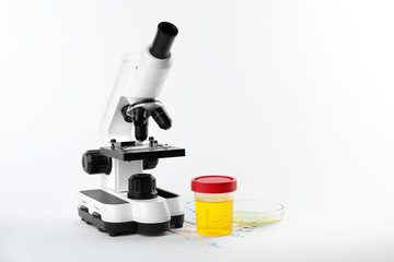 Laboratory ware with urine samples for analysis and microscope on white background