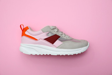 Stylish women's sneaker on pink background, top view
