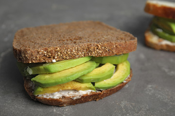 Tasty avocado sandwich on grey table, closeup