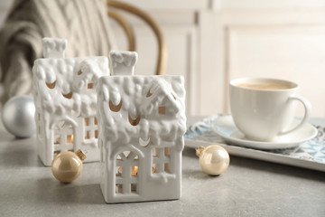 Composition with house shaped candle holders on light table. Christmas decoration