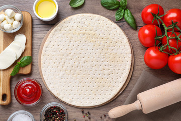 Flat lay composition with fresh ingredients for pizza Margherita on wooden table