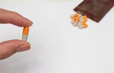 finger holded medical drug capsule before  oral take in medical healthcare consumption concept with copy space