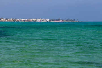 Turquoise and warm waters in Tunisia with a view of an island.