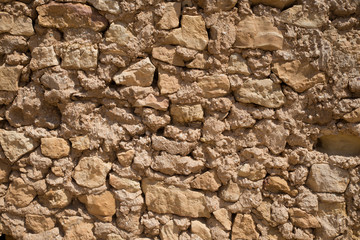 Yellow stone texture with rough edges in cement. Wall of shelters in the desert of Tunisia.