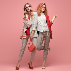 Two fashionable woman sisters in Trendy autumn red elegant outfit, stylish hair, makeup hugging....