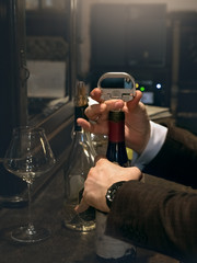 The sommelier opens a bottle of red vintage wine. Close up.