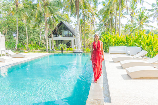 Young lady in a red dress on a vacation in a luxury resort