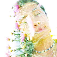Double exposure portrait of a young, relaxed natural beauty with head tilted sideways and long brown hair combined with green tropical leaves and bright pink flowers on a white background