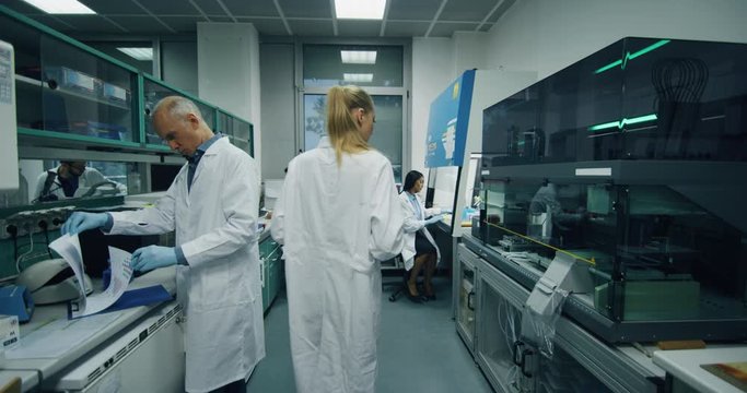Slow motion shot of scientists work in research lab - Powered by Adobe