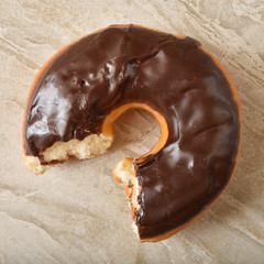Chocolate donut with a missing bite