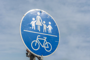 Verändertes Verkehrsschild mit einer Frau und drei Kindern als Metapher für veraltete...