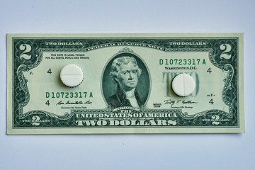 Pills on dollar money isolated on white background. Medicine expenses , one way road