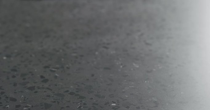 Slow motion man hand bring brown paper gift box on terrazzo countertop