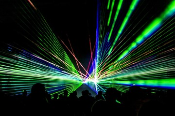 Laser show rays stream. Very colorful show with a crowd silhouette and great laser rays at youth party festival - 298526628