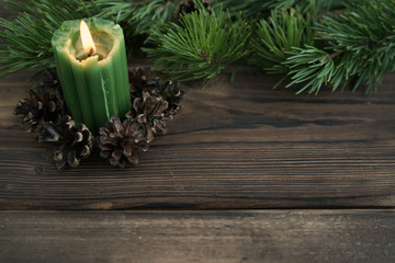 Pine branches and a burning candle  