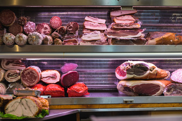 Italian ham and sausages on a shelf in a shop