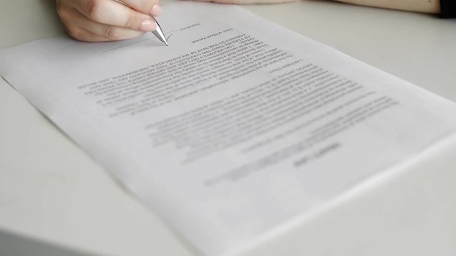 Politician woman is signing draft law. Person heand signs the document