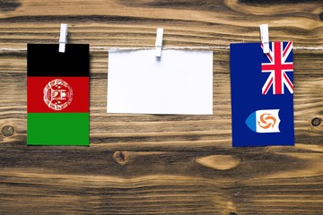 Hanging flags of Afghanistan and Anguilla attached to rope with clothes pins with copy space on...