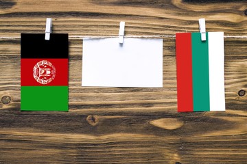Hanging flags of Afghanistan and Bulgaria attached to rope with clothes pins with copy space on...