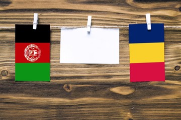 Hanging flags of Afghanistan and Chad attached to rope with clothes pins with copy space on white...