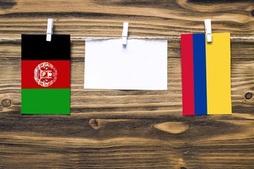 Hanging flags of Afghanistan and Colombia attached to rope with clothes pins with copy space on...
