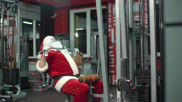 Santa Claus training at the gym on Christmas Day. exercise-machine.