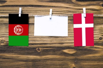 Hanging flags of Afghanistan and Denmark attached to rope with clothes pins with copy space on...