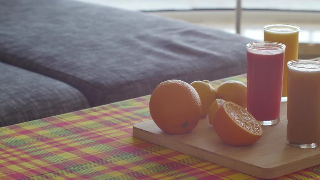 Soft pan of fruit platter and juices on wooden plate. orange, lemon grapefruit and watermelon, many colors and many vitamins, healthy food on Caribbean style table with madras pattern