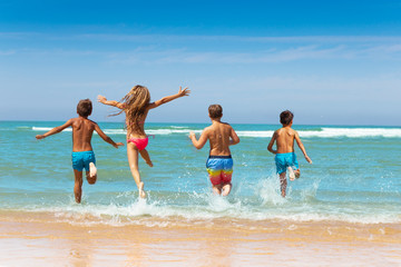 Girl jump into water with friends group on beach