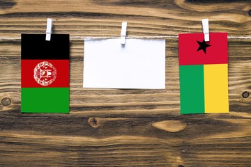 Hanging flags of Afghanistan and Guinea Bissau attached to rope with clothes pins with copy space...