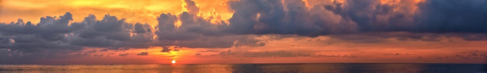 Phuket beach sunset, colorful cloudy twilight sky reflecting on the sand gazing at the Indian Ocean, Thailand, Asia.