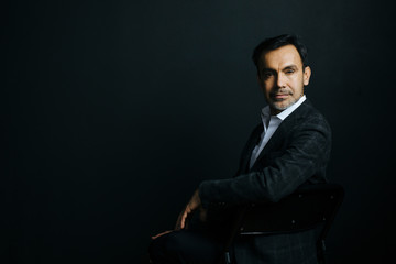 Portrait of a mature, stylish man on black studio background