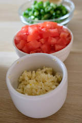 Vertical row of bowls of minced vegetables