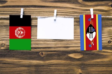 Hanging flags of Afghanistan and Swaziland attached to rope with clothes pins with copy space on...