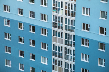 Fototapeta premium Windows of a multi-storey building opposite the blue-white color. Without people